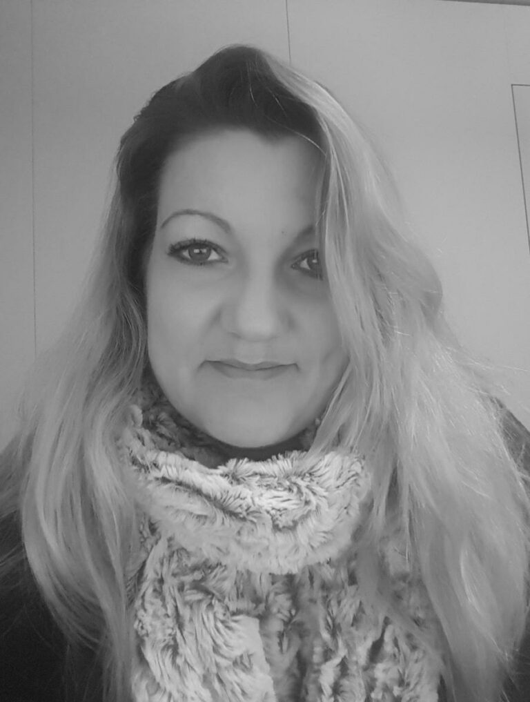 Eine Frau mit langen Blond Haar und einer Muffler